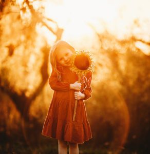 child holding large sunflower