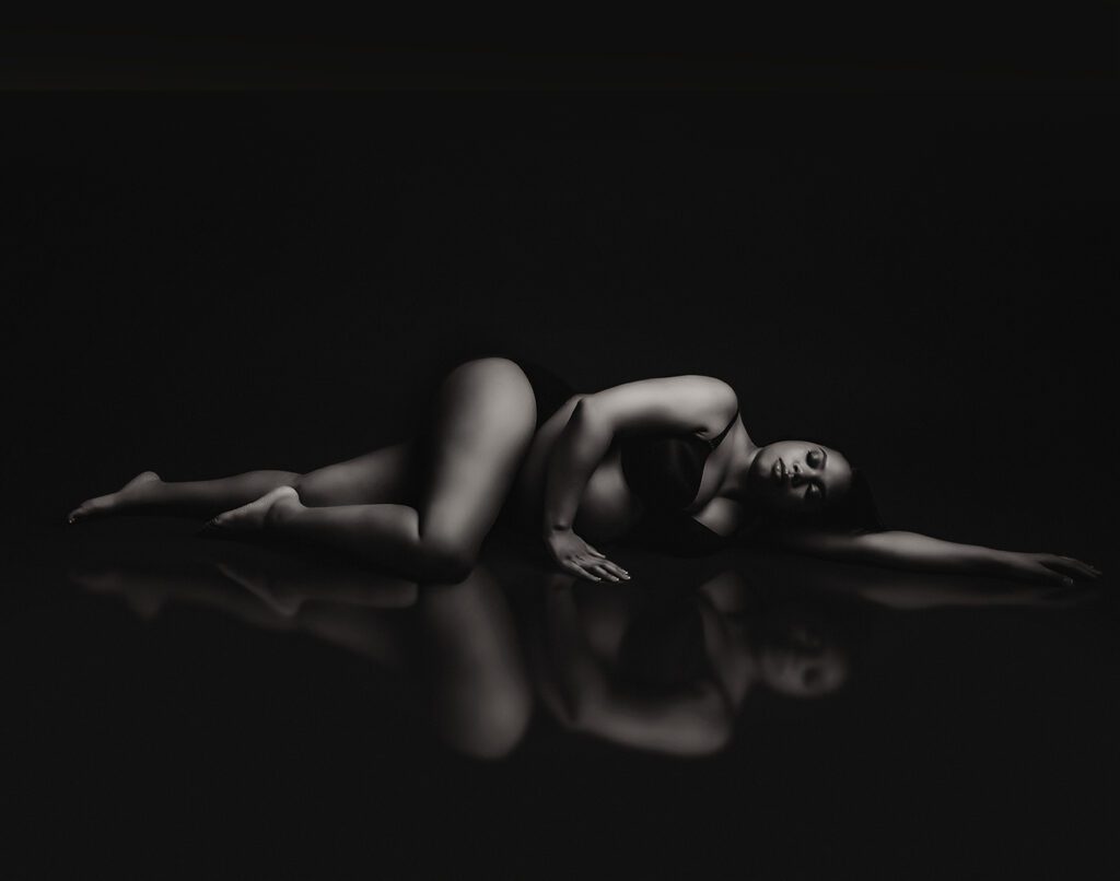creative maternity photo in black and white mom laying on studio floor