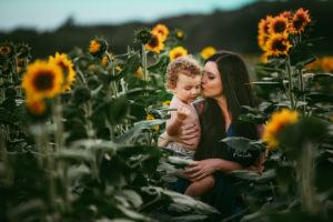 mom kissing her son in flowers