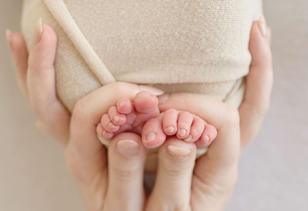little details of moms hands and baby's toes