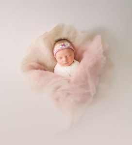 sleeping newborn in pink fluff niccole photography