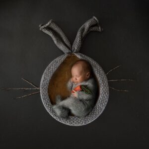 newborn baby sleeping in rabbit bowl